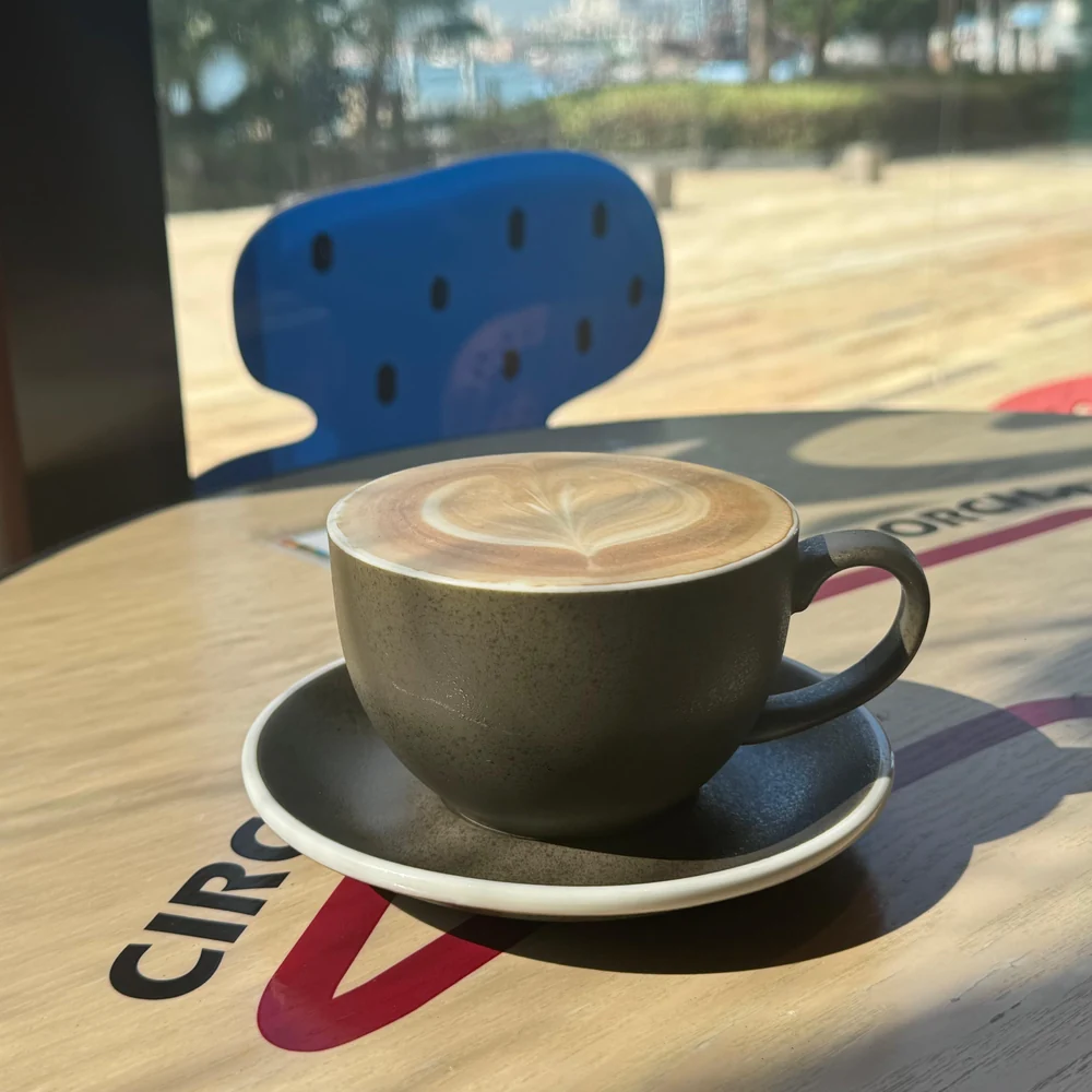A cup of coffee with latte art on a window-side table at SSP Café